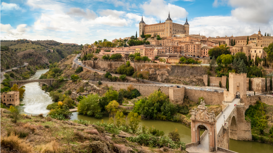 Toledo cityscape with Alcantara bridge (Puente de Alcantara) over Targus river. Spain