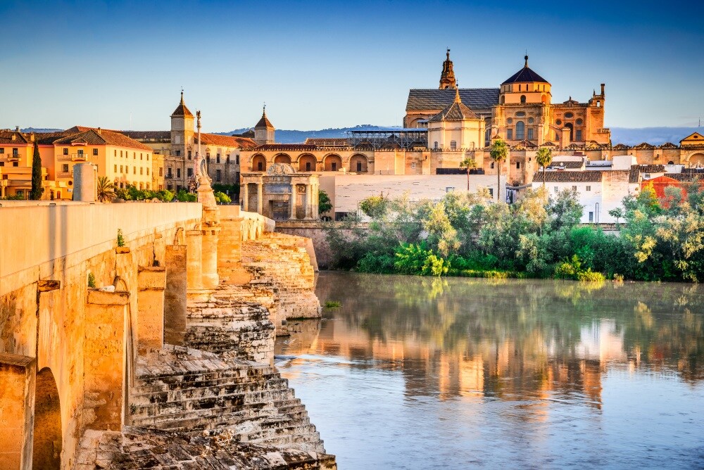 Cordoba, Spain. Roman Bridge on Guadalquivir river and The Great Mosque (Mezquita Cathedral) at twilight in the city of Cordoba, Andalusia. (Cordoba, Spain. Roman Bridge on Guadalquivir river and The Great Mosque (Mezquita Cathedral) at twilight in th